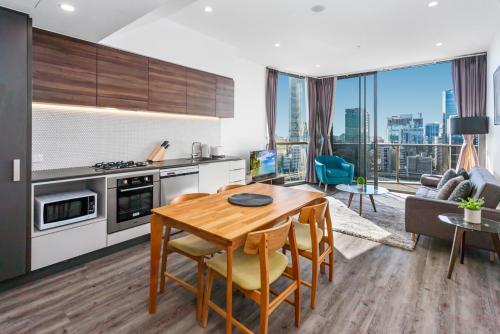 a kitchen and living room with a table and a couch at River-View Unit with Rooftop Pool near Museums in Brisbane