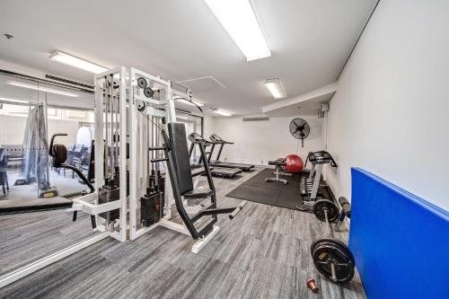 a gym with treadmills and machines in a room at Central 2-bed Apartment with Pool, Gym and Spa in Canberra