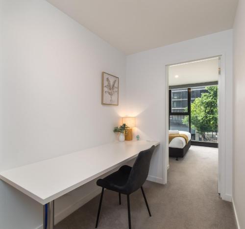 a white desk in a room with a chair at Chic 3-Bed in Central with Pool, Sauna and Gym in Canberra