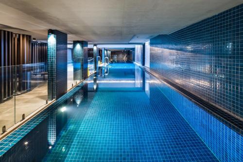 a swimming pool in a building with blue tiles at Chic 3-Bed in Central with Pool, Sauna and Gym in Canberra