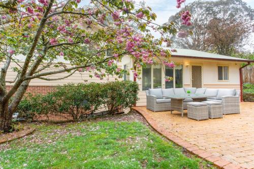 a patio with couches and a table in front of a house at Stunning Katoomba Home with Lush Garden&Playground in Katoomba