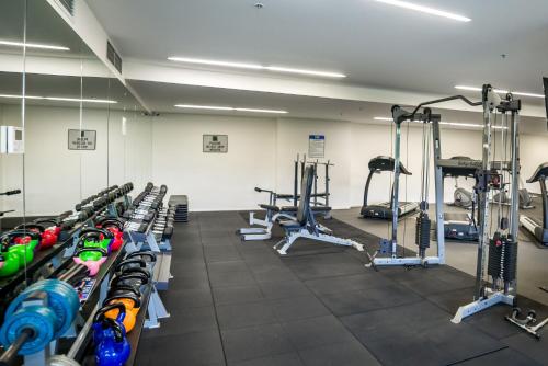 a gym with a bunch of treadmills and machines at Executive Balcony Apartment in Central Canberra in Canberra
