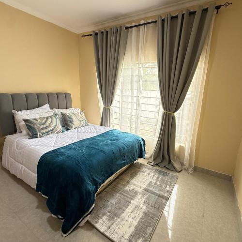 a bedroom with a bed and a window with curtains at Rest Haven Apartments Meanwood in Lusaka