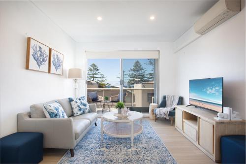 a living room with a couch and a tv at MadeComfy Trendy Apartment on Dee Why Beach in Deewhy