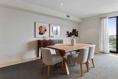 a dining room with a wooden table and chairs at Spacious 3-Bed Apartment by the MCG in Melbourne