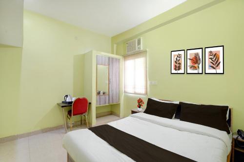 a bedroom with a large bed and a red chair at Collection O Rajgir Railway Junction Formerly Hotel Mamta Kutir in Rājgīr