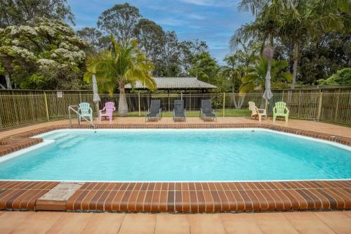 une grande piscine avec des chaises et un gazebo dans l'établissement Batemans Bay Studio Escape with Lush Vista, à Batehaven