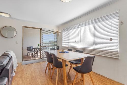 Un comedor con mesa y sillas en Cosy 2-Bedroom Seaside Unit Steps from Beach, en Maroochydore