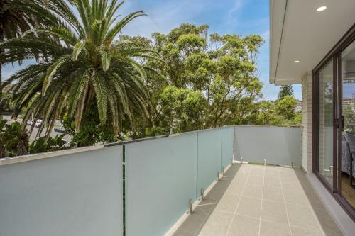 an empty balcony with a palm tree in the background at North-East Facing Modern 2-bed Apartment in Freshwater