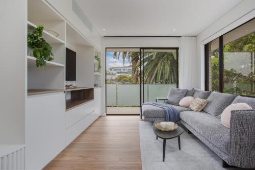 a living room with a couch and a table at North-East Facing Modern 2-bed Apartment in Freshwater