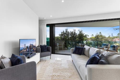 a living room with a couch and a large window at Spacious and Superb 3-bed Apartment in Brisbane