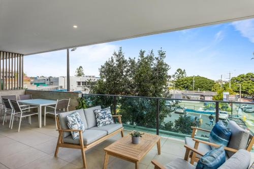 a balcony with a couch and chairs and a table at Spacious and Superb 3-bed Apartment in Brisbane