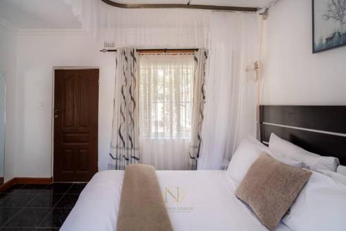 Ένα ή περισσότερα κρεβάτια σε δωμάτιο στο New Dawn Lodge