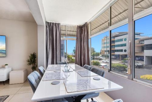 a dining room with a table and chairs and a large window at Family-Friendly Stay Walk to Beach & Parks in Maroochydore