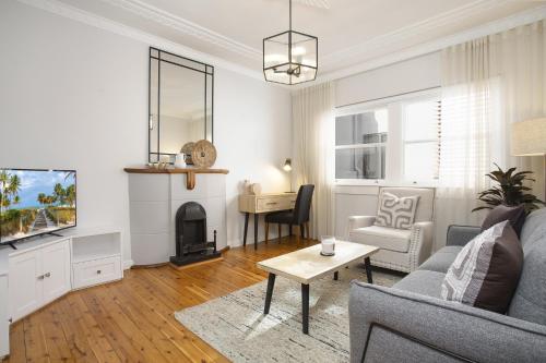 a living room with a couch and a tv at Coastal Living Just Metres From Coogee Beach in Sydney