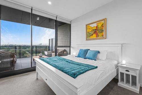 a bedroom with a large bed and a balcony at A taste of paradise in inner city suburbia in Melbourne