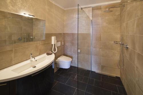 a bathroom with a sink and a shower and a toilet at Boutique Hotel Albergo Brione in Locarno