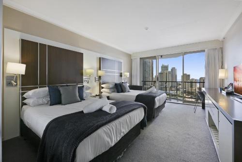 a hotel room with two beds and a balcony at Ocean View 2-Bed Studio In the Heart of Surfers in Gold Coast