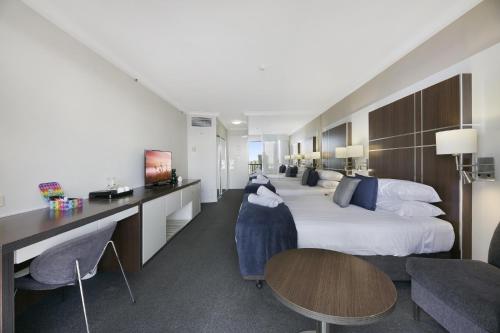 a hotel room with a large bed and tables and chairs at Ocean View 2-Bed Studio In the Heart of Surfers in Gold Coast