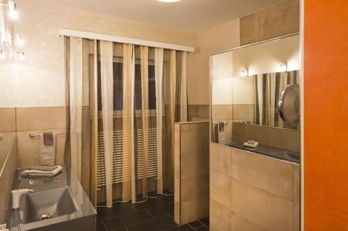 a bathroom with a sink and a toilet and a mirror at Boutique Hotel Albergo Brione in Locarno