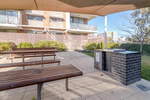 deux bancs et un gril devant un bâtiment dans l'établissement Exquisite Apartment with BBQ and Pool, near Shops, à Phillip