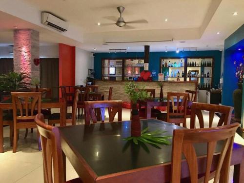 un restaurant avec une table et des chaises ainsi qu'un bar dans l'établissement Victoria Palms Hotel, à The Domain