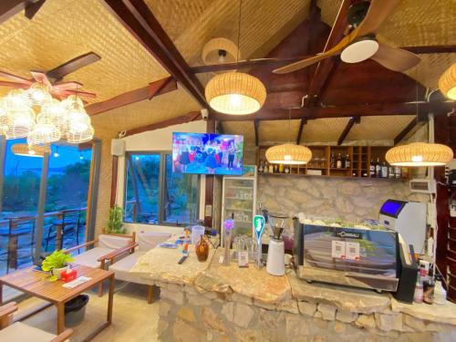 Una sala de estar con una mesa y una pared de piedra. en Sunrise Hill Koh Rong, en Kaôh Rŭng (3)