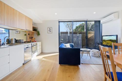 a kitchen and living room with a table and chairs at Cosy 1-Bed with Private Balcony By Showgrounds in Melbourne
