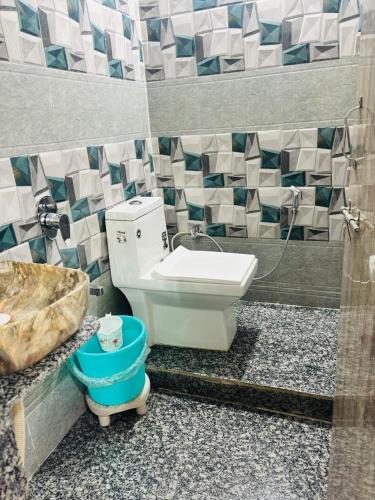 a bathroom with a toilet and a sink and a tub at Hotel New Sun and Rock in Mount Ābu