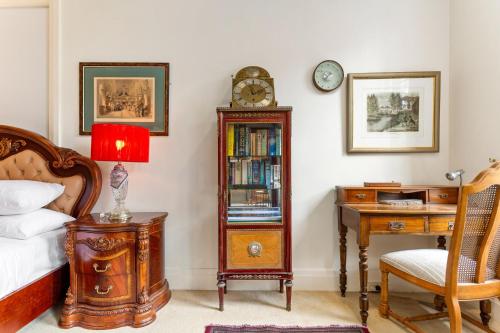 a bedroom with a bed and a desk and a clock at Eclectic Art Deco Apartment in great location in Sydney