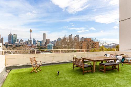 a balcony with a table and chairs and a view of the city at Eclectic Art Deco Apartment in great location in Sydney