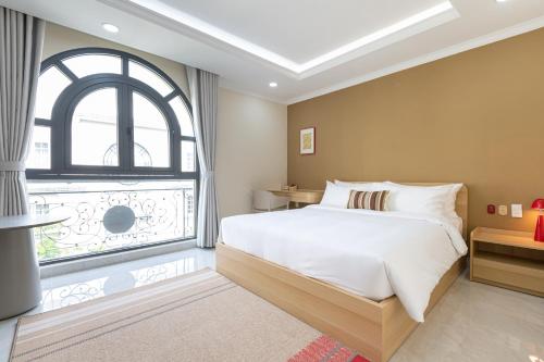胡志明市Thankee Hotel VN的一间卧室，里面有一张床和一扇大窗户。