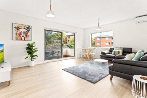 a living room with a couch and a table at Bright and convenient apartment, close to shops in Sydney