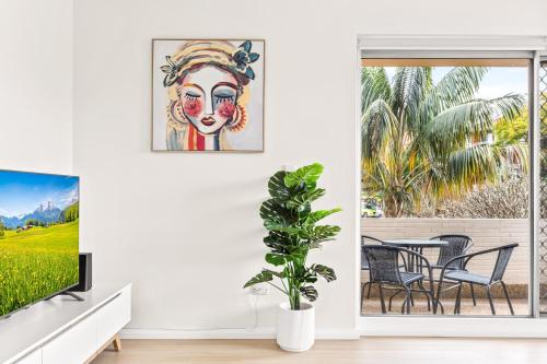 a living room with a painting of a woman at Bright and convenient apartment, close to shops in Sydney