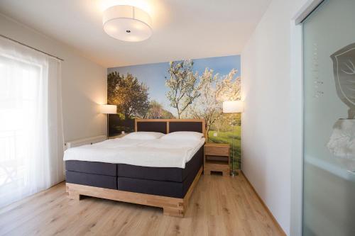 a bedroom with a bed and a painting on the wall at Hotel & Wirtshaus Hödl-Kaplan in Feldbach