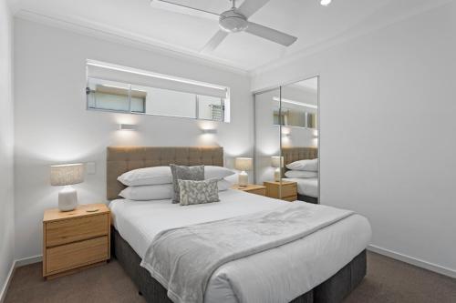 a bedroom with a large bed and a mirror at Chic 2-Bed Apartment & 5 minutes walk to QPAC in Brisbane