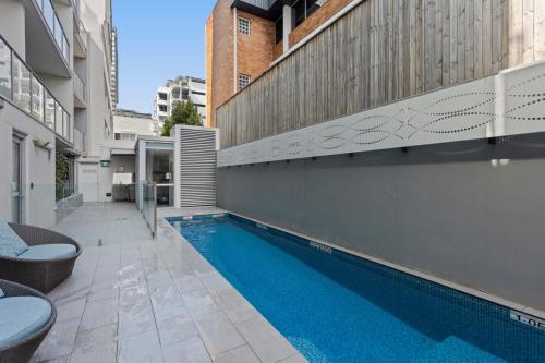 a swimming pool in the side of a building at Chic 2-Bed Apartment & 5 minutes walk to QPAC in Brisbane