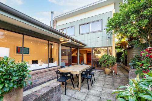 an outdoor patio with a wooden table and chairs at Delightful 4-Bed Home near Centennial Park in Sydney