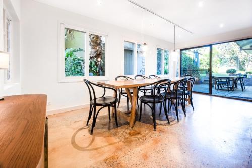 a dining room with a wooden table and chairs at Delightful 4-Bed Home near Centennial Park in Sydney