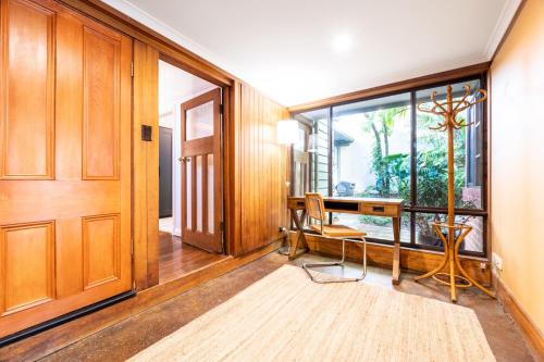 a hallway with a desk and a door with a window at Delightful 4-Bed Home near Centennial Park in Sydney