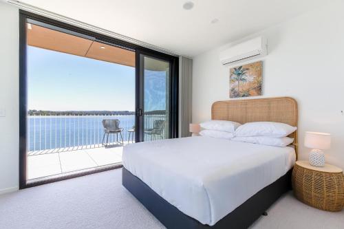 a bedroom with a bed and a view of the water at Lavish Coastal 2-Bed with Stunning Ocean Views in Batemans Bay