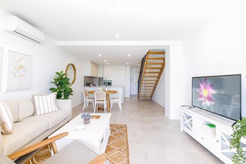 a living room with a couch and a tv at Lavish Coastal 2-Bed with Stunning Ocean Views in Batemans Bay