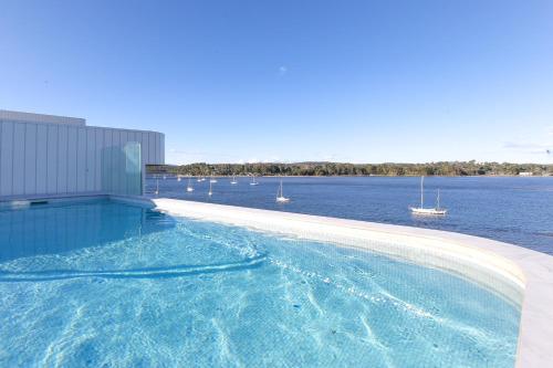 a swimming pool with a view of a body of water at Elegant Bay Side 1-Bed Apartment with Views in Batemans Bay