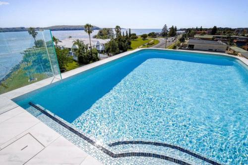 a swimming pool with a view of the ocean at Elegant 2-Bed Apartment with Stunning Views in Batemans Bay