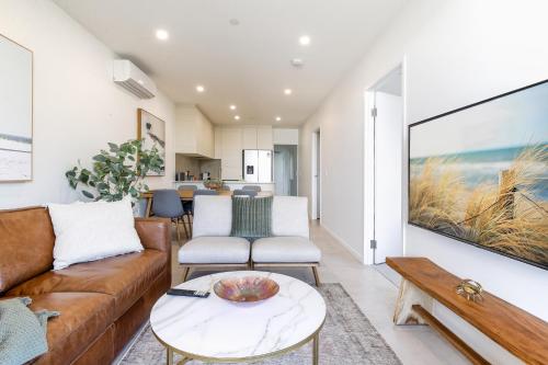 a living room with a couch and a table at Elegant 2-Bed Apartment with Stunning Views in Batemans Bay