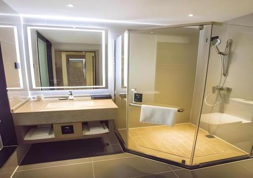 ein Badezimmer mit Dusche, Waschbecken und Spiegel in der Unterkunft City Comfort Inn Nanchang Fuxing Avenue East Metro Station Xiaolan in Xiaolancun