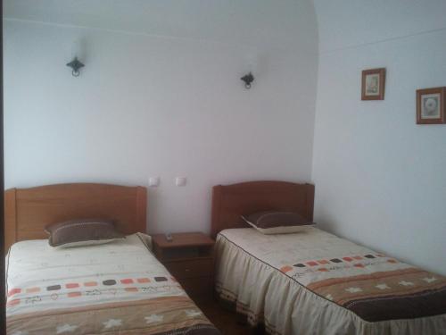 two beds in a room with white walls at A Casa in Portel