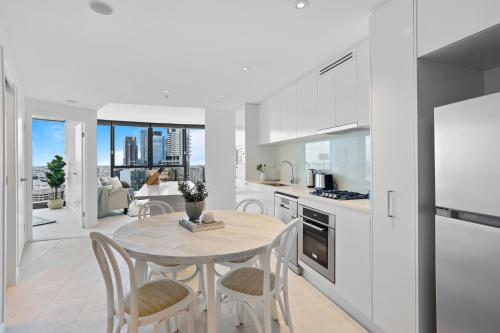 a kitchen and dining room with a table and chairs at Breathtaking City Views 1-Bed with Pool, BBQ & Gym in Brisbane