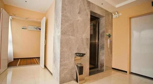 a hallway with a stone wall and a doorway at City Comfort Inn Deyang Wenmiao Square Gymnasium in Deyang