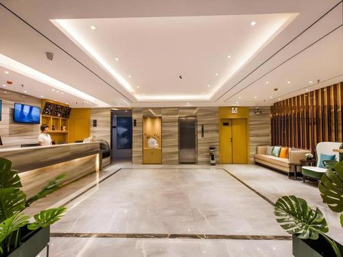 Die Lobby eines Hotels mit gelben Wänden und Pflanzen in der Unterkunft City Comfort Inn Shaoguan High-speed Railway Station Xilian Examination Center in Shaoguan